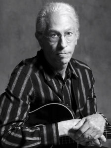 Joel Rafael with guitar black and white photo.